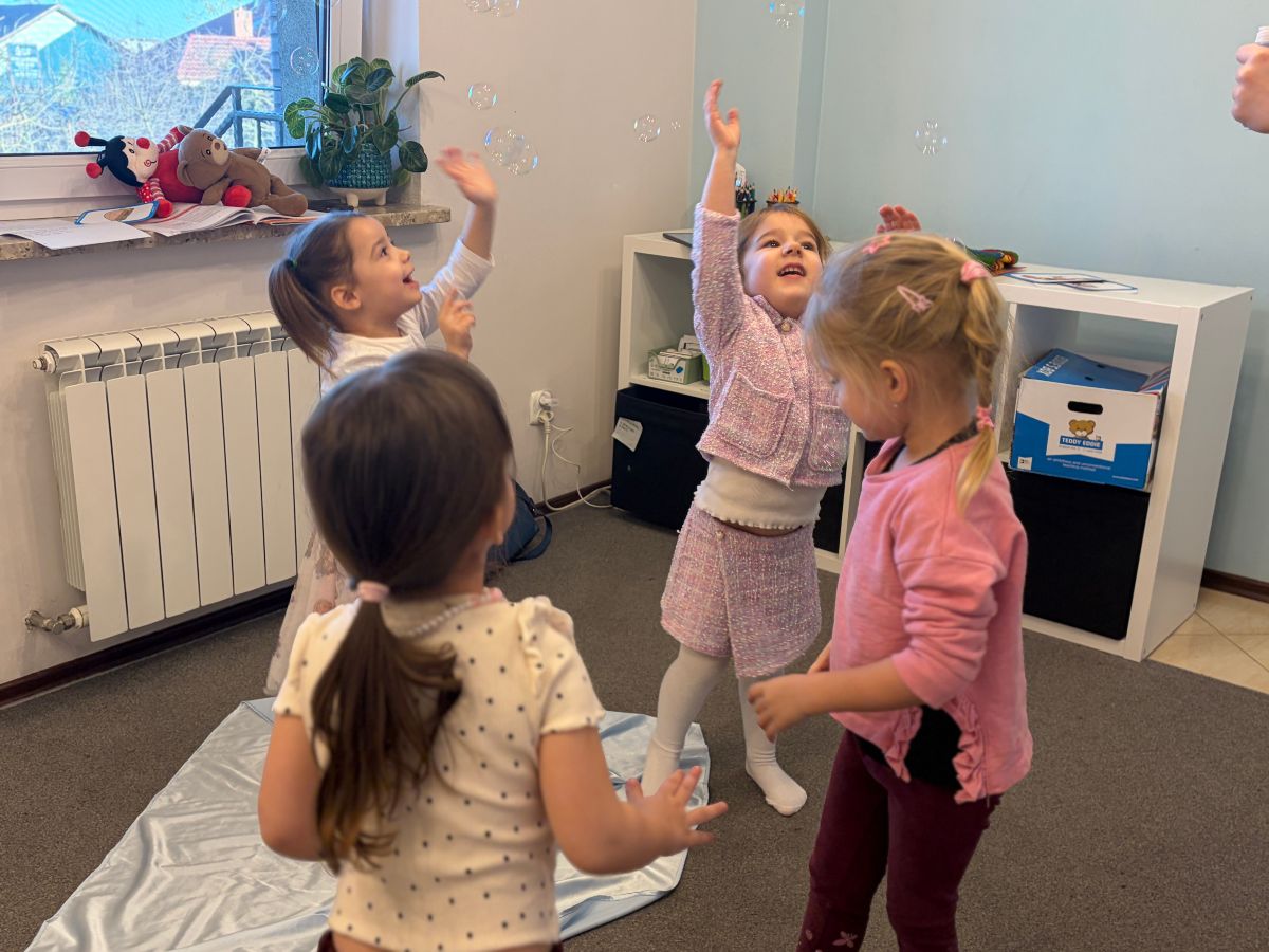 Dzieci łapią bańki na zajęciach Teddy Eddie